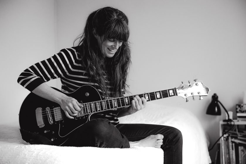 A portrait image of Julie Doiron playing guitar in black and white.