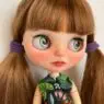 A custom OOAK Blythe doll with brunette hair in pig tails.