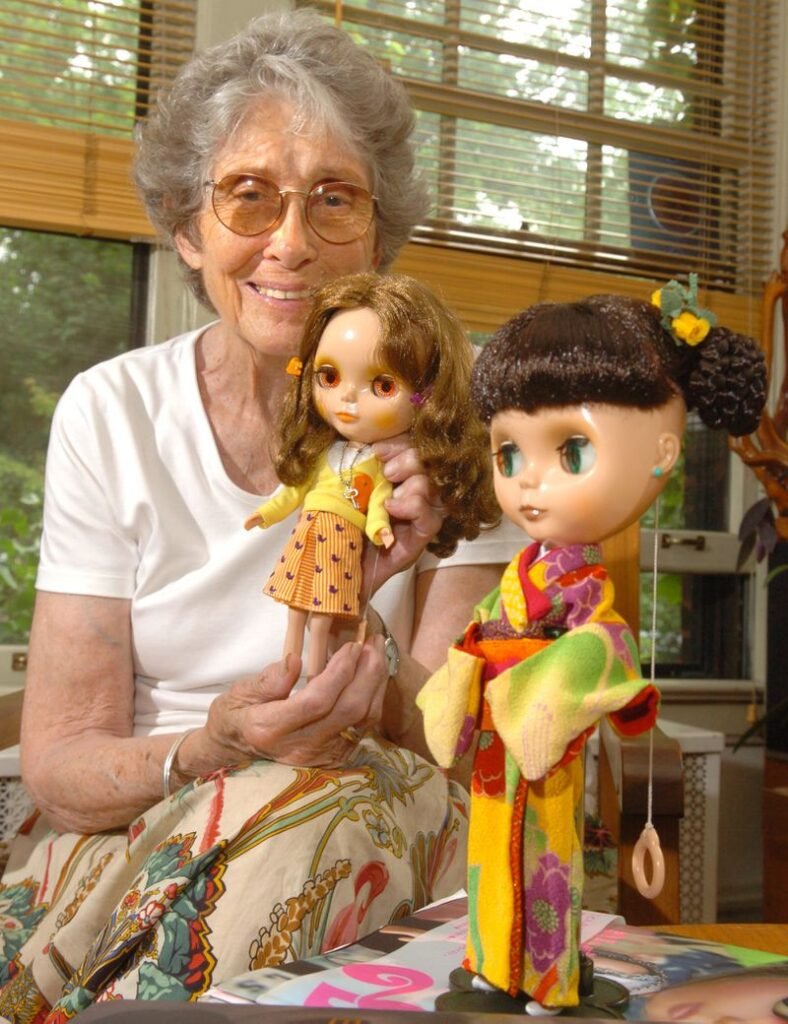 A portrait of Allison Katzman, the creator of Blythe dolls, with two of her creations.