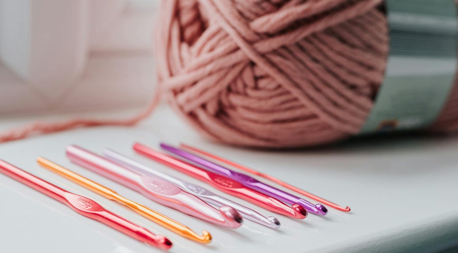 crochet needles and threads on windowsill