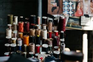Spools of antique thread on a stand in a dimly lit room.