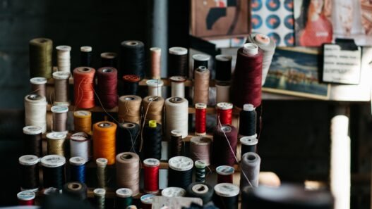 Spools of antique thread on a stand in a dimly lit room.