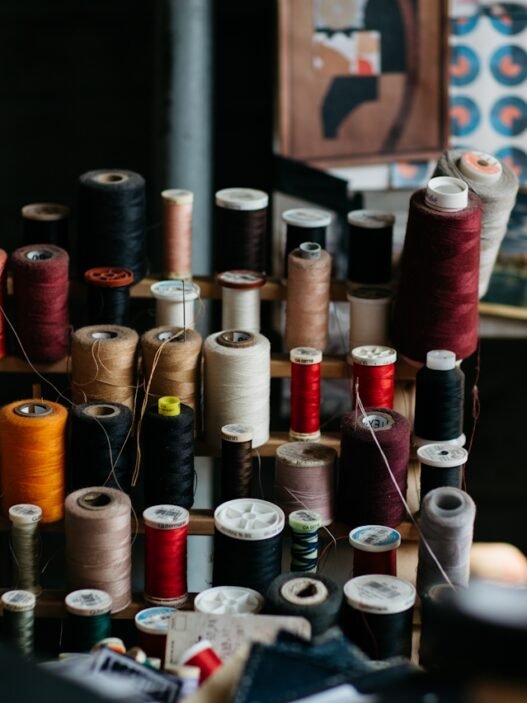 Spools of antique thread on a stand in a dimly lit room.