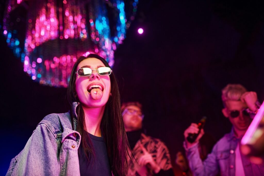 A group of people at a night club. The person in the foreground is sticking out their tongue.