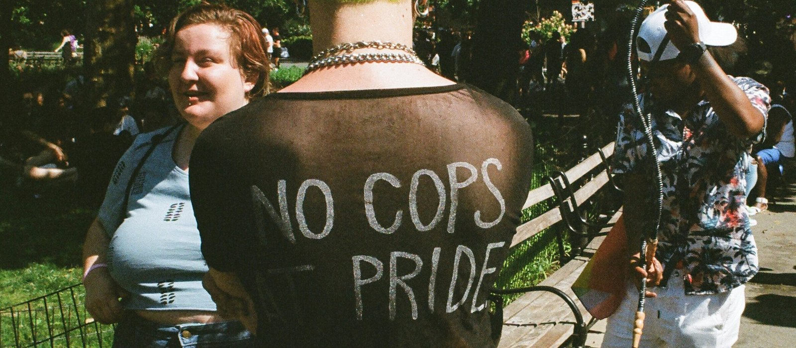 A punk with the writing 'No Cops at Pride' on the back of their shirt.