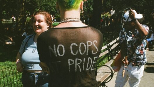 A punk with the writing 'No Cops at Pride' on the back of their shirt.