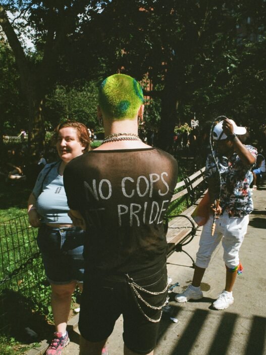 A punk with the writing 'No Cops at Pride' on the back of their shirt.