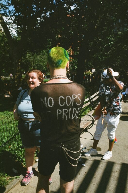 A punk with the writing 'No Cops at Pride' on the back of their shirt.