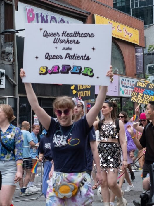Protesters at a Pride parade supporting queer healthcare workers and patients.